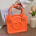 Vibrant orange EVA tote bag featuring a heart relief design and metal rivet handle - Orange