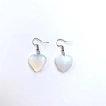 Detailed close-up of heart-shaped opal glass earrings with silver hooks on white background - Opalite