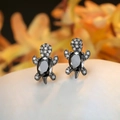 Macro shot of turtle stud earrings with black stones and white cubic zirconia accents - Black Gold Plated Black Zircon