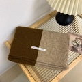 Chic two-tone knit scarf in brown and beige with a minimalist label on a wooden desk - Khaki + Brown