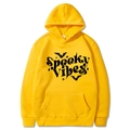 Detail of Spooky Vibes text and bat print on a yellow Halloween hooded sweatshirt - Yellow