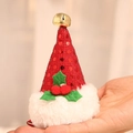 Rode kerstmuts haarclip met pailletten, gouden bel en hulstblaadjes in de hand - Rode Pailletten Clip