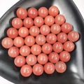 Polished round orange crystal stone spheres on a black display tray for home decor - 25mm No Hole Sphere / Watermelon red
