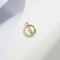 Macro shot of gold-plated D-letter pendant with sparkling rhinestones on grey surface - Gold White