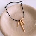 Detailed shot of fish bone and fish charms on adjustable black cord necklace - Gold
