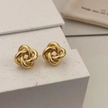 Detailed view of elegant gold twisted knot stud earrings on a minimalist white display - Gold Knot Studs