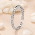 Anello regolabile color argento con ritagli a forma di cuore su superficie beige caldo - Cuore Cavo Argento