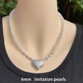 Detalle de collar de perlas de 6 mm con colgante de corazón mate en un maniquí - 6mm / Plateado