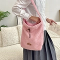 Close-up of pink faux shearling shoulder bag featuring leather label and plaid lining - Pink