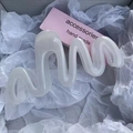 Elegant large wavy white shark hair claw clip for thick hair displayed on white paper - Jelly White