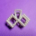 Elegant bow-shaped hair claw clip with white pearls on a purple textured background - Double Rhombus Hollow