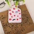 Pink heart and eye pattern mini hot water bottle for hand warming on a vintage notebook - Red Lips