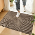Brown and black PVC door mat with spiral texture shown on wood floor with sneakers - 45*75cm / Geometric Space - Khaki (Silk Loop)