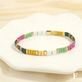 Detail shot of colorful Tila bead stretch bracelet on a decorative ceramic shell tray - BR1670-F/Pink Green White Mix