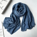 Blue modal scarf with subtle stripes and fringe edge on a white wooden tabletop - Navy Blue