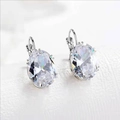 Elegant lever-back earrings with oval-cut clear gemstones in a polished silver setting - White