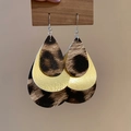 Macro detail of multi-layered teardrop earrings featuring leopard print and gold accents - Teardrop-Gold