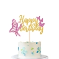 Makroansicht goldener Happy Birthday Kuchendeckel mit rosa glitzernden Schmetterlingen - Rosarot