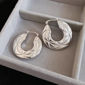 Detailed macro view of silver hoop earrings with engraved starburst diamond patterns - Silver