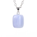 Macro detail of natural light blue crystal pendant with silver chain on white background - Silver Tone + Light Blue