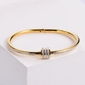 Elegante brazalete de acero de titanio dorado con cristales sobre base geométrica blanca - Dorado