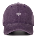 Close-up of embroidered bee on washed dark purple cotton baseball cap with vintage texture - Purple