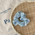 Chouchou blanc translucide aux fleurs bleues sur un plateau en bambou tressé - Tulipe Bleue