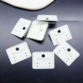 Close-up of white PVC earrings display card with Fashion Jewelry text on gray surface - 4*3cm