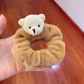 Brown plush hair scrunchie with a cute white teddy bear ornament held over wood background - Scrunchie-Brown Bear