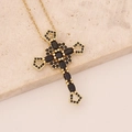 Detailed view of golden cross pendant with black zircon stones on marble background - Black