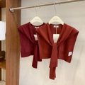 Detailed close-up of knitted wool shawls in dark red and brick red with tie-front design - Dark Red