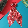Detail of red silk Christmas scrunchie with reindeer pattern and long ribbon streamers - Red