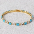 Detailopname van een vergulde armband met turkoois en heldere zirkonia steentjes - Turquoise & Wit Zirkon Goud