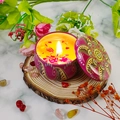 Candela profumata in latta etnica rosa con petali di fiori secchi e fiamma accesa - Fico