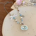 Détail de collier avec pendentif étoile de mer et nœud ruban blanc dans un plat décoratif - 9# Collier-Bleu-Blanc (Nœud Coquillage Perle Chaîne en Argent Épissage)
