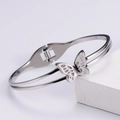 Detailed view of silver butterfly bangle with hollow design and white sparkling crystals - Steel