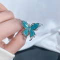 Détail macro d'une broche papillon en émail bleu avec un strass central scintillant - Style 5 Bague Ouverte Papillon