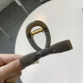 Detail view of a vintage dark grey translucent bow hair claw clip with golden metal spring - Medium 8cm / Dark Gray