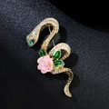 Macro shot of gold snake brooch with pink enamel flower and rhinestones on black - Snake Shape Pink Flower Style