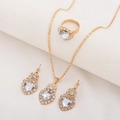 Detailed flat lay of golden heart pendant necklace earrings and ring set with crystals - Three-Piece Set / Heart-White