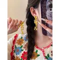 Close-up of yellow flower tassel earrings with intricate beads on a female model - Yellow Flower Beaded Tassel (16# Silver Earring Post)