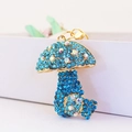 Sparkling blue rhinestone mushroom keychain with gold metal frame and colorful accents - Blue