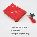 Detail of red tassel wallet with heart embroidery and star charm on white background - Red