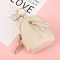Beige mini backpack coin purse with litchi texture, tassel detail, and gold hardware - Beige