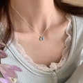Close-up of minimalist silver necklace with round light blue gemstone pendant on model - Light Blue Round Gem Style (XL2671)