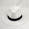 Close-up of white woven straw sun hat with black ribbon detail on plush background - M (56-58cm) / White