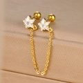 Gold star chain earrings with sparkling cubic zirconia on a jewelry box background - Gold