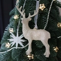 Adornos brillantes de reno y estrella color champán colgados en un árbol de Navidad verde - Reno Vintage Plata Champaña 14CM