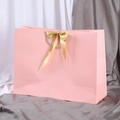 Pink paper gift bag with a luxury champagne gold ribbon bow and woven handles - XS (19x15x7cm) / Pink