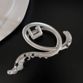 Detail view of matte silver hair claw with sparkling pink rhinestones and black stars - Oval
